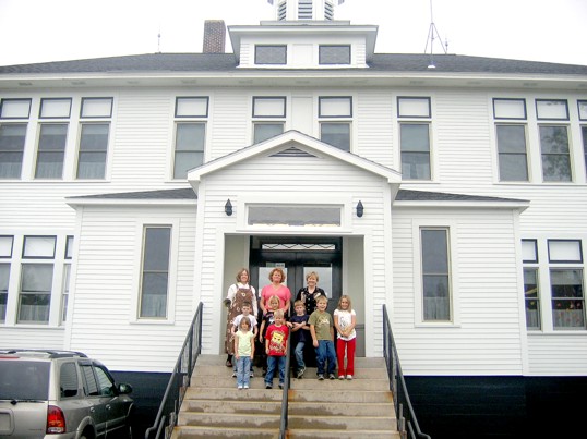 The front entrance of the school, with teachers and students gathered on the steps.